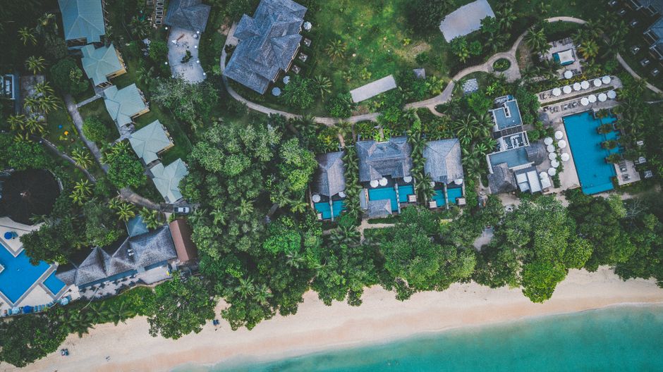 Stunning aerial view of a beachfront resort surrounded by lush greenery in Beau Vallon, Seychelles.