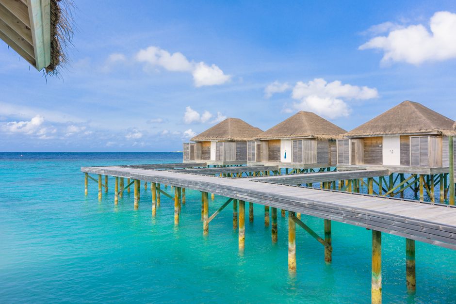 Idyllic scene of overwater bungalows in Maldives with turquoise ocean and clear sky.